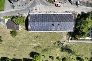 Luftbild des Gasthauses mit fertig wirkendem Dach und angrenzender Wiese